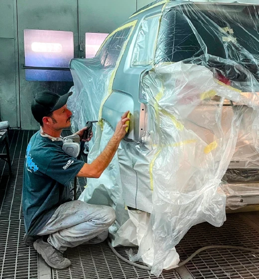 Technician sanding car panel