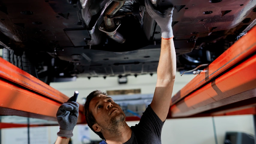 Mechanic inspecting vehicle frame
